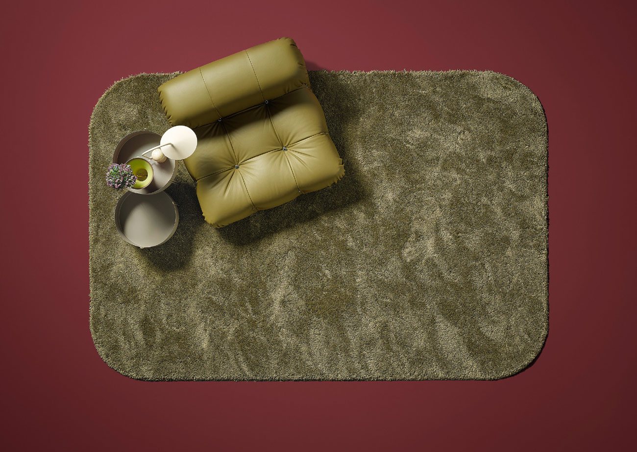 Rounded-corner miroo Curve rug with a green armchair